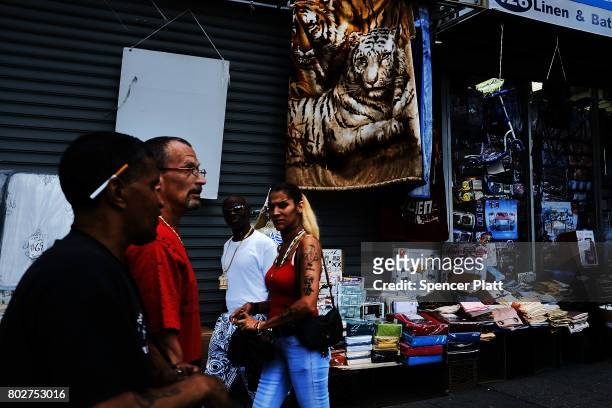 People walk on the street following the release of a report that says poverty has risen on June 28, 2017 in New York City. According to a recent...
