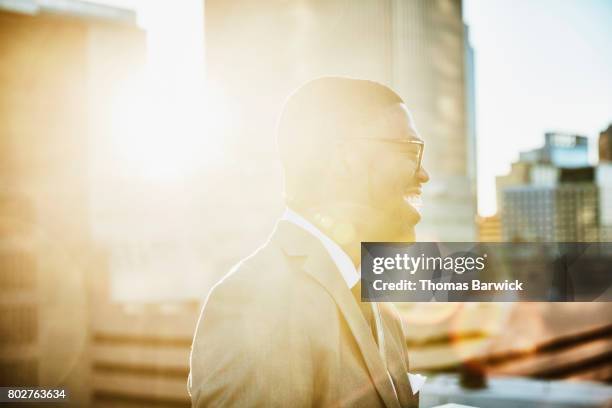 laughing businessman standing on downtown office deck at sunrise - white collar worker dawn light stock pictures, royalty-free photos & images