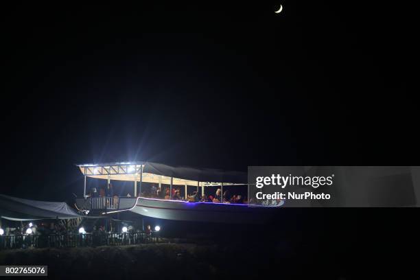 Palestinians sit inside a boat, in one of the recreational facilities on the Gaza beach on the third day of Eid al-Fitr holiday in Gaza City on June...