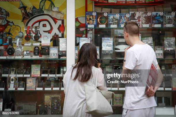 People are seen looking at second hand electronics at a CEX shop in Bydgoszcz, Poland on 27 June, 2017. CEX is a British chain of shops that buys and...