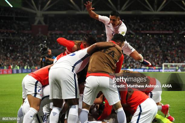 Alexis Sanchez of Chile jumps on to Claudio Bravo with his team-mates as they celebrate winning a penalty shootout during the FIFA Confederations Cup...