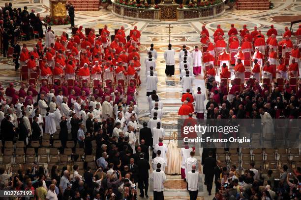 Pope Francis walks through the central navata of St. Peter's Basilica with five newly appointed cardinals during a consistory at St. Peter's Basilica...