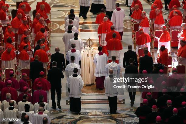 Pope Francis walks through the central navata of St. Peter's Basilica with five newly appointed cardinals during a consistory at St. Peter's Basilica...