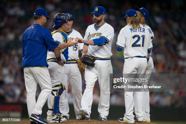 Relief pitcher Marc Rzepczynski, third from right, is pulled by Seattle Mariners manager Scott Servais, far left, during a meeting at the pitcher's...