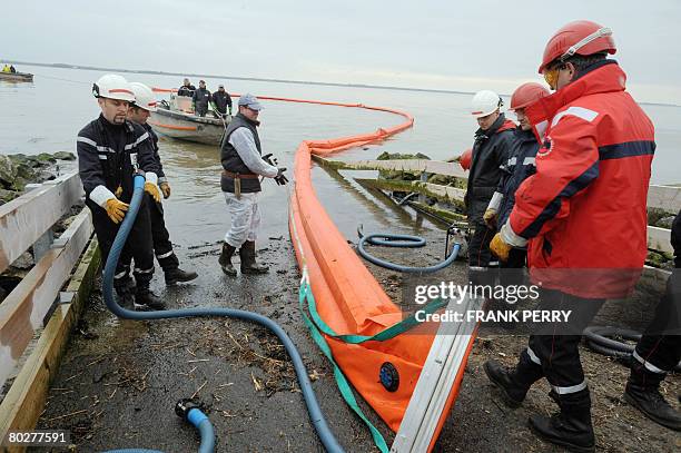 Des pompiers mettent ? l'eau un barrage flottant pr?s de la raffinerie Total de Donges, le 17 mars 2008 suite ? une pollution provoqu?e par une fuite...