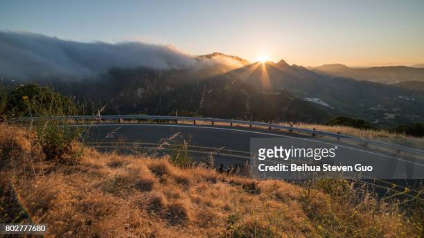view of curved piuma road and malibu marine layer during sunset in santa monica mountains national recreation area, california - piuma stock pictures, royalty-free photos & images