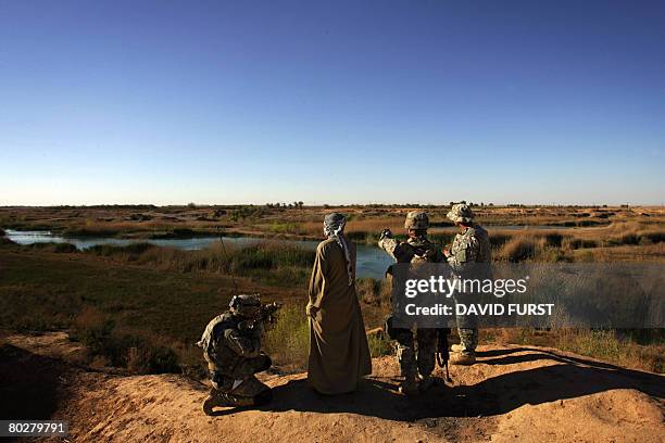 Sunni tribal leader and US soldiers from Iron Company 3rd Squadron 2nd Stryker Cavalry Regiment look at the Diyala river valley at a crossing point...