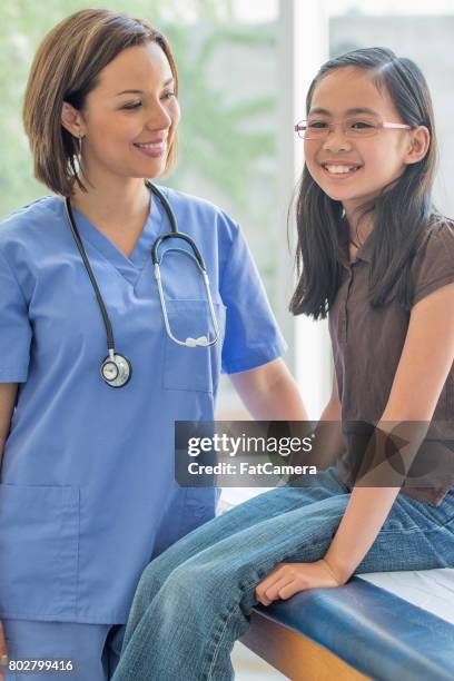 zittend op examen tafel - cute nurses stockfoto's en -beelden