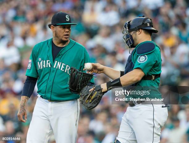 Starting pitcher Felix Hernandez of the Seattle Mariners and catcher Mike Zunino of the Houston Astros meet at the mound during a game against the...