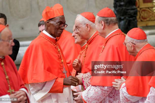 New Cardinal Jean Zerbo greets by other Cardinals after he received the red three-cornered biretta hat from Pope Francis during the Ordinary Public...