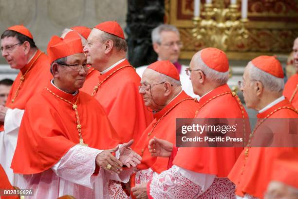 New Cardinal Louis-Marie Ling Mangkhanekhoun greets by other Cardinals after he received the red three-cornered biretta hat from Pope Francis during...