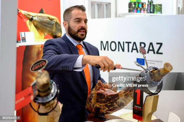 Man cuts Jamon Serrano at the Montaraz stand as he attends the Annual Summer Fancy Food Show on June 26,2017 at the Javits Center in New York City.