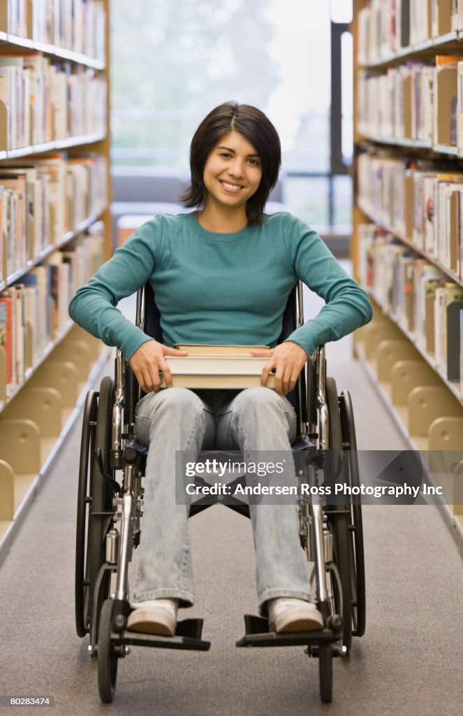 Mixed Race woman in wheelchair at library