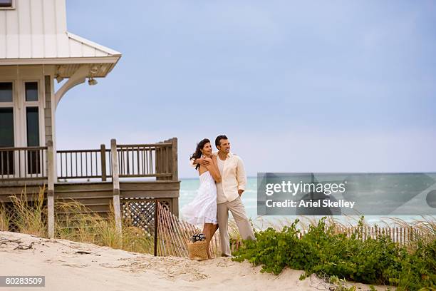 hispanic couple hugging on beach - pareja de mediana edad fotografías e imágenes de stock