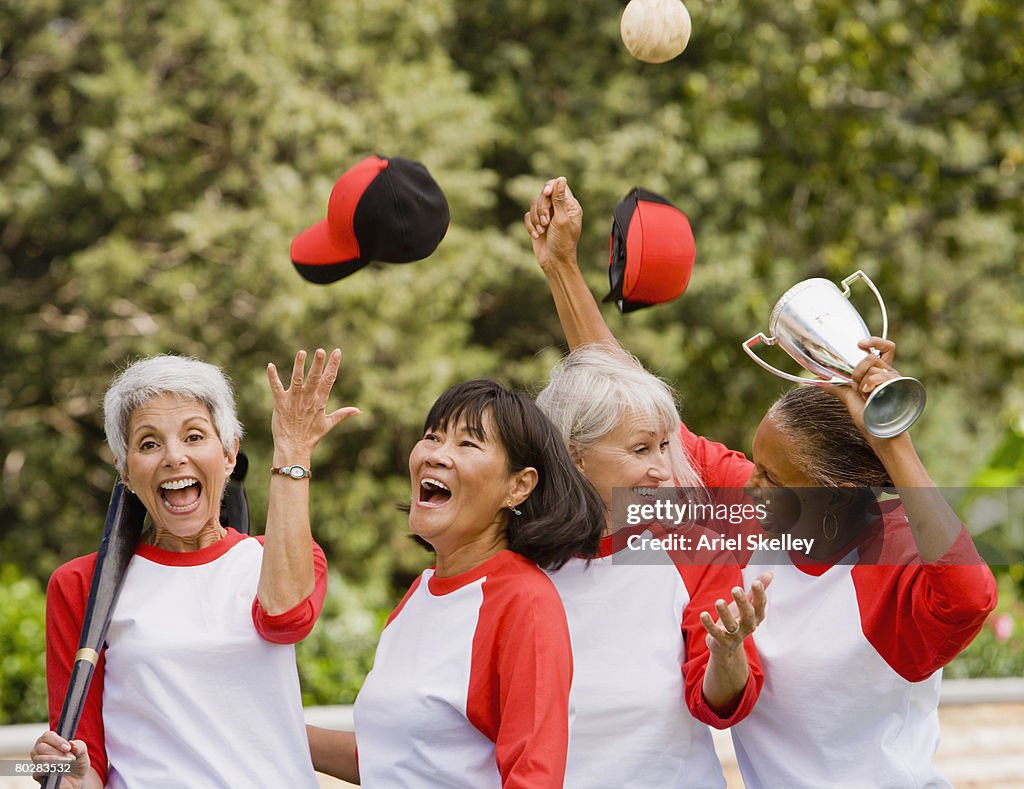 Multi-ethnic senior women in baseball uniforms cheering