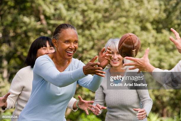 multi-ethnic senior women playing football - throwing football stock pictures, royalty-free photos & images