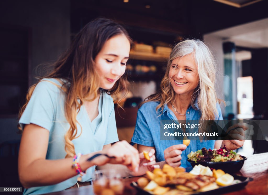 Beautiful senior mother and daughter eating lunch together at restaurant