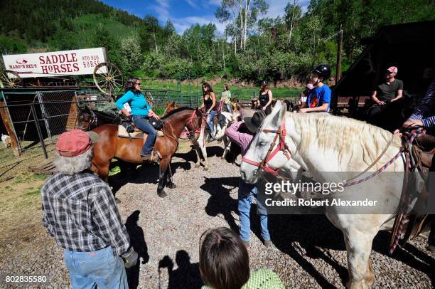 Guide gives instructions to a group of young horseback riders before the group heads out on a morning ride in the Maroon Bells-Snowmass Wilderness of...
