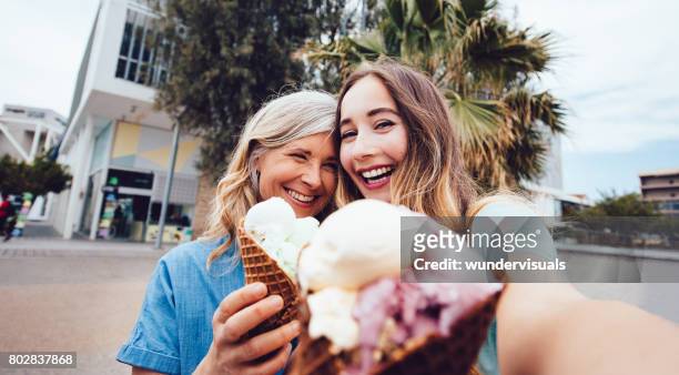 ältere mutter und tochter unter einem selfie beim essen eis - teenager alter stock-fotos und bilder