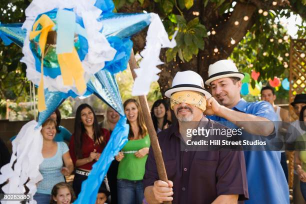 hispanic man trying to hit pinata - old trying to look young stock pictures, royalty-free photos & images
