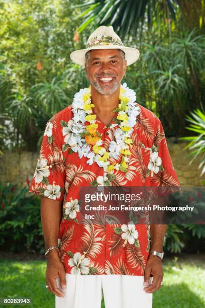 african man wearing hawaiian shirt and leis - man flower shirt fotografías e imágenes de stock