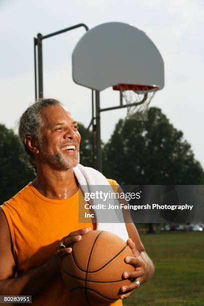 african man holding basketball - basket ball stock-fotos und bilder