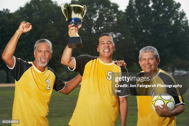 multi-ethnic men holding soccer trophy - trophy day 3 stock pictures, royalty-free photos & images