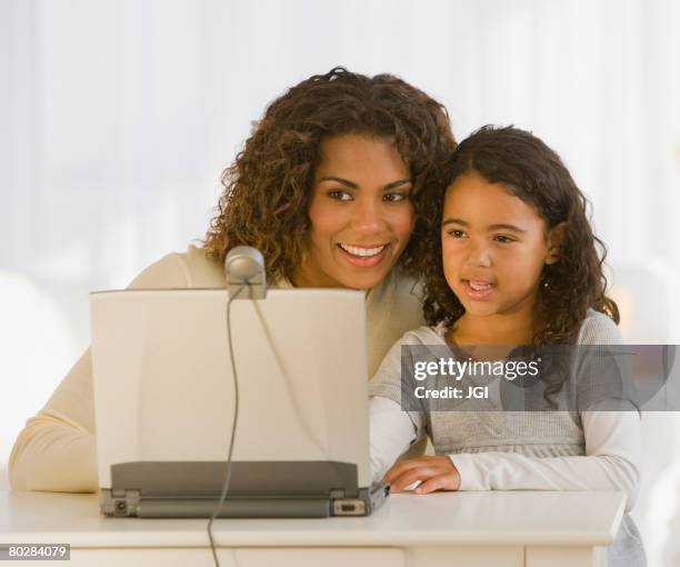 african mother and daughter looking at web cam - cam girl stock pictures, royalty-free photos & images