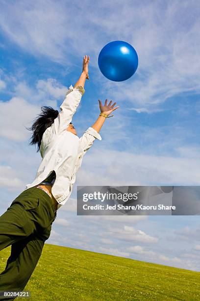 asian woman jumping for ball - woman catching stock pictures, royalty-free photos & images