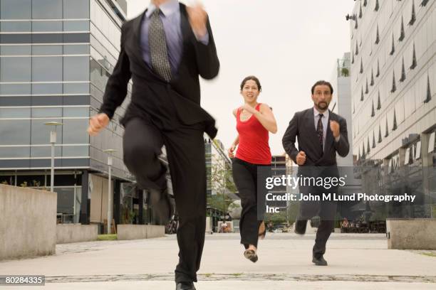 multi-ethnic businesspeople running - verfolgen stock-fotos und bilder