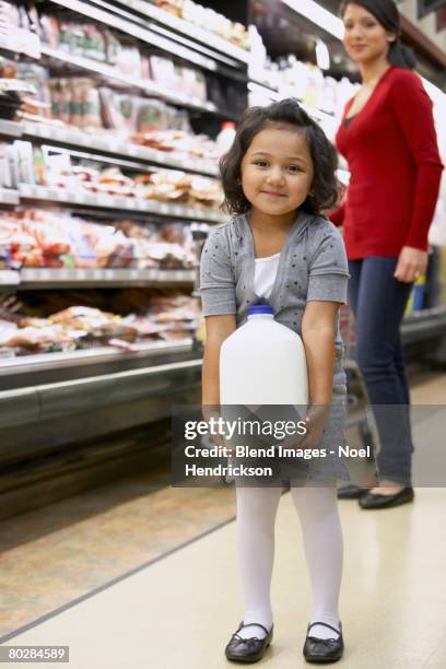 indian girl carrying milk in grocery store - mom buying milk photos et images de collection