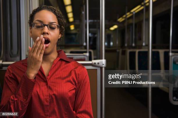 african businesswoman yawning on train - overdoing stock pictures, royalty-free photos & images