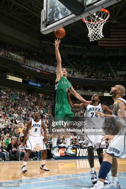 Jose Calderon of the Toronto Raptors goes up for a layup past Paul Millsap and Carlos Boozer of the Utah Jazz at EnergySolutions Arena on March 17,...