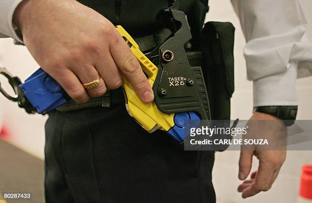 File photo taken 05 December 2007 shows a British police officer holding a taser gun during a training session at the Metropolitan Police Specialist...