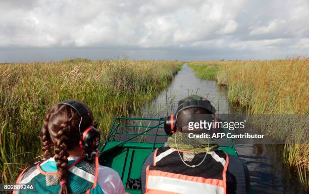 War veteran Chad Brown and Riley Brooks ride through the Everglades during an airboat tour at the Arthur R. Marshall Loxahatchee National Wildlife...