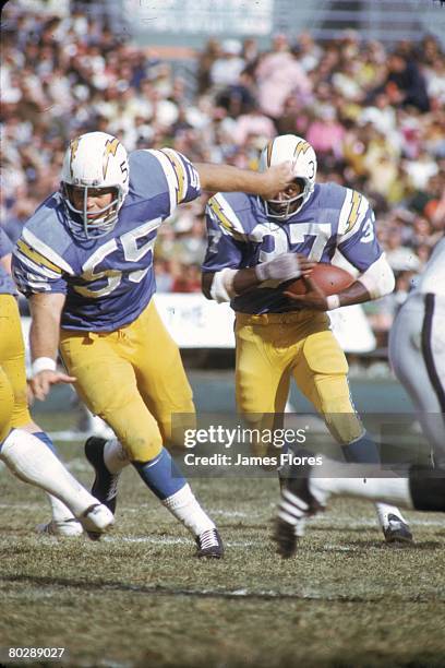 Guard Ralph Wenzel of the San Diego Chargers leads running back Cid Edwards against the Oakland Raiders at San Diego Stadium on December 3, 1972 in...