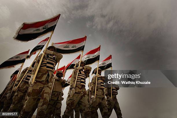 Iraqi army soldiers from the 4th Brigade of the 5th Division march with Iraqi flags during their graduation ceremony at Besmaya Range Complex on...