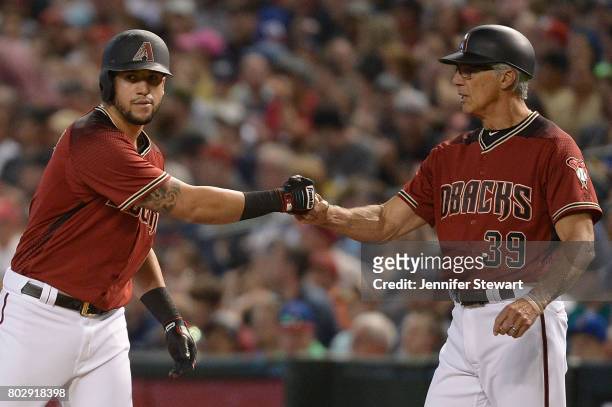 David Peralta of the Arizona Diamondbacks fist bumps with first base coach Dave McKay after singling on a line drive against the Milwaukee Brewers in...
