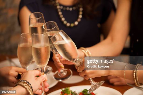 close-up of the hands of the girls making a toast. - jantar imagens e fotografias de stock