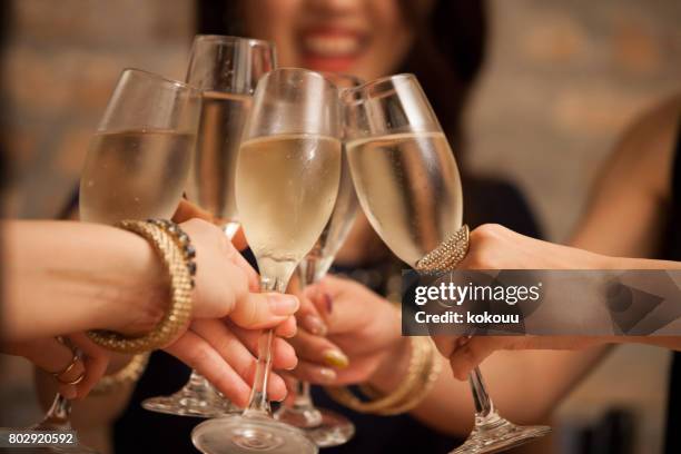 business-frauen stoßen mit einem glas wein in der hand. - champagne toast stock-fotos und bilder