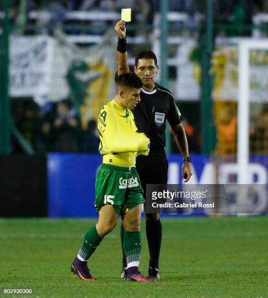 Referee Diego Haro shows a yellow card to Nicolas Stefanelli of Defensa y Justicia during a first leg match between Defensa y Justicia and...