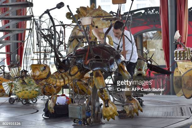 An employee fixes a mechanical turtle made of wood and steel in the "Carrousel des Mondes Marins" of "Les Machines de L'Ile" in Nantes, western...
