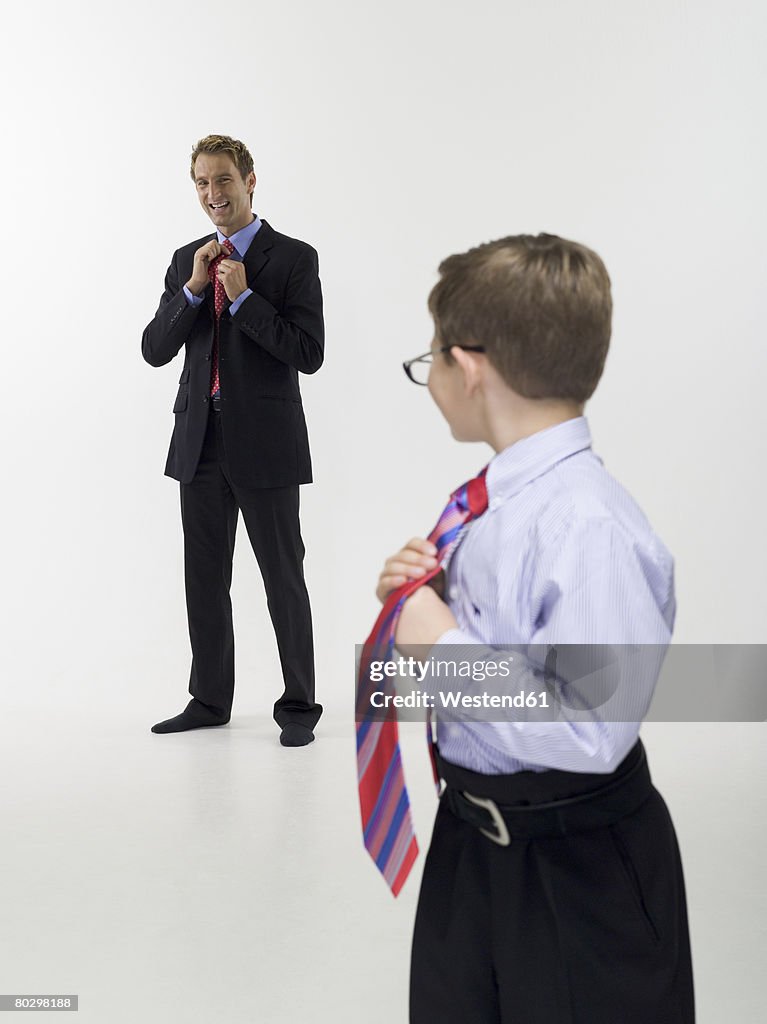 Father and son (8-9) in business clothing, portrait