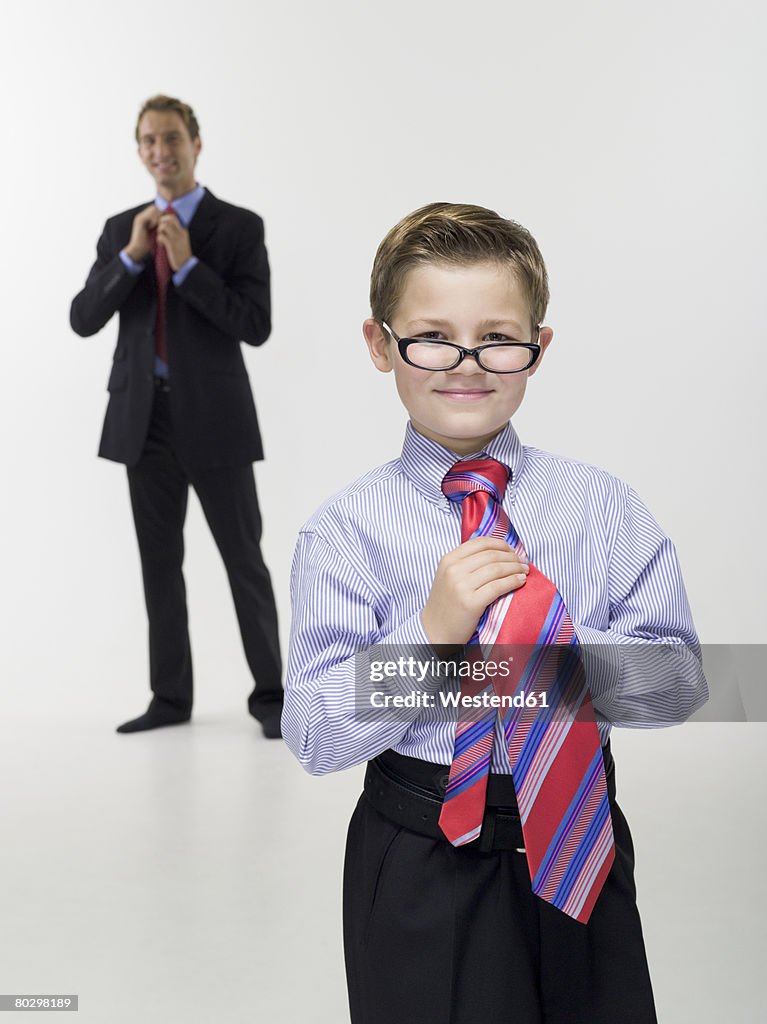 Father and son (8-9) in business clothing, portrait