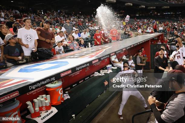 David Peralta of the Arizona Diamondbacks throws water onto fans before the start of the MLB game against the St. Louis Cardinals at Chase Field on...