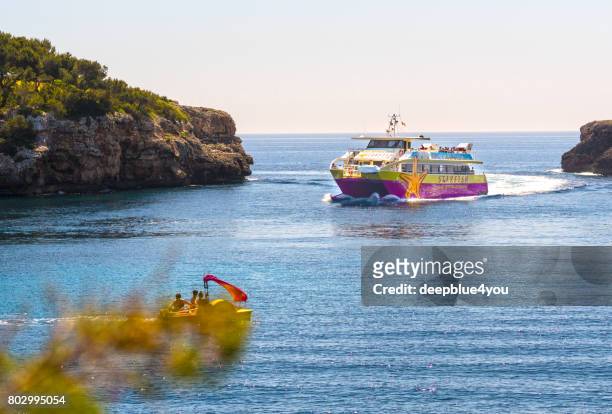 starfish cruising boat, cala d,or, majorca, spain - beach at cala d'or stock pictures, royalty-free photos & images