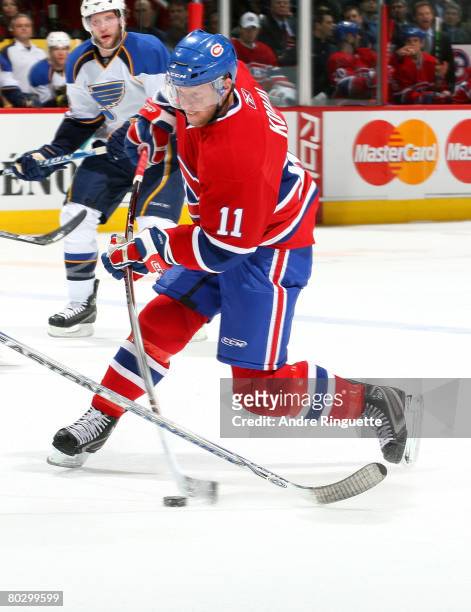 Saku Koivu of the Montreal Canadiens bends his stick taking a shot against the St. Louis Blues at the Bell Centre on March 18, 2008 in Montreal,...