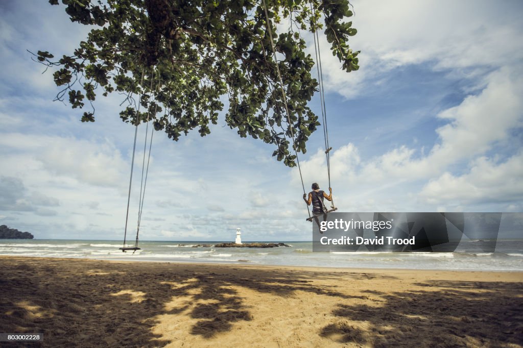 Man on swing by the sea