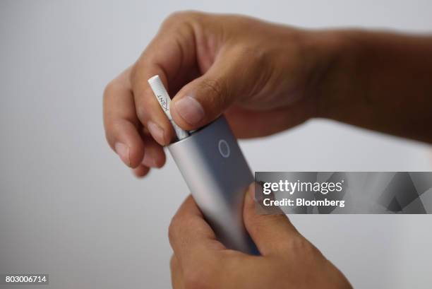 Customer holds British American Tobacco Plc's Glo smokeless tobacco device in Tokyo, Japan, on Monday, June 26, 2017. By next week, smokeless devices...