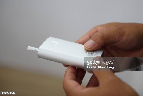 Customer holds British American Tobacco Plc's Glo smokeless tobacco device in Tokyo, Japan, on Monday, June 26, 2017. By next week, smokeless devices...